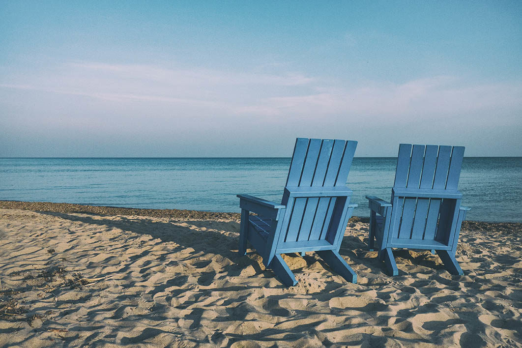 two blue beach chairs near body of water
