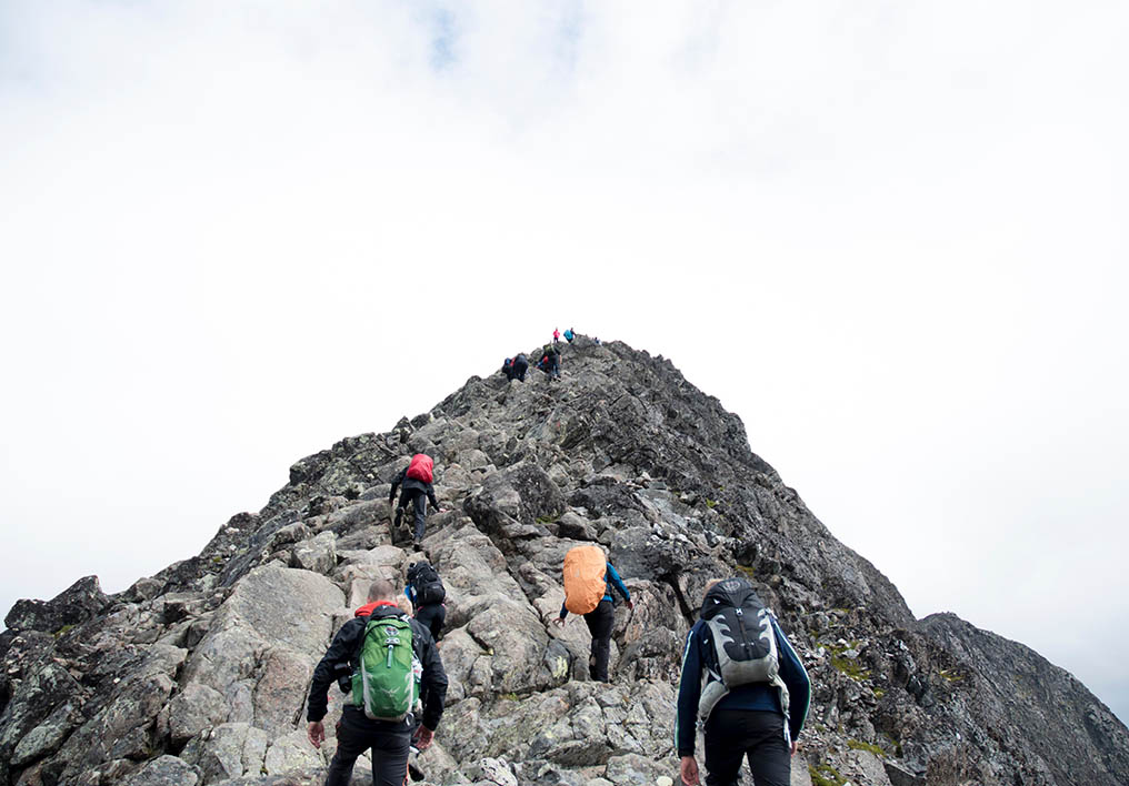 climbers helping climb mountain